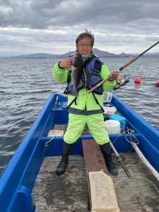 船上でソイを釣りあげた笑顔の男性