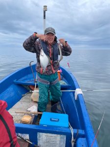 船上でソウハチを釣りあげた笑顔の男性