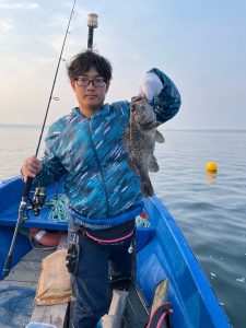 船上でソイを釣りあげた笑顔の男性