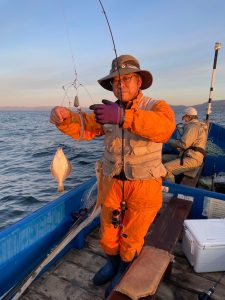 船上でソウハチを釣りあげた笑顔の男性