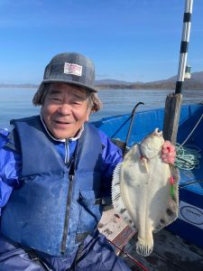 船上でクロガシラを釣りあげた笑顔の男性