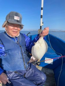 船上でマガレイを釣りあげた笑顔の男性
